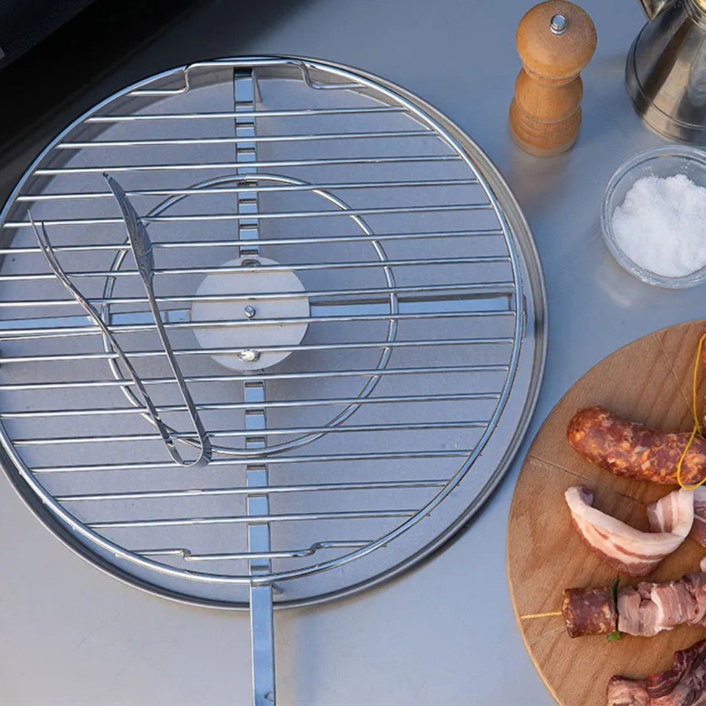 Alfa BBQ grill grid on a table with skewered meats and seasonings.