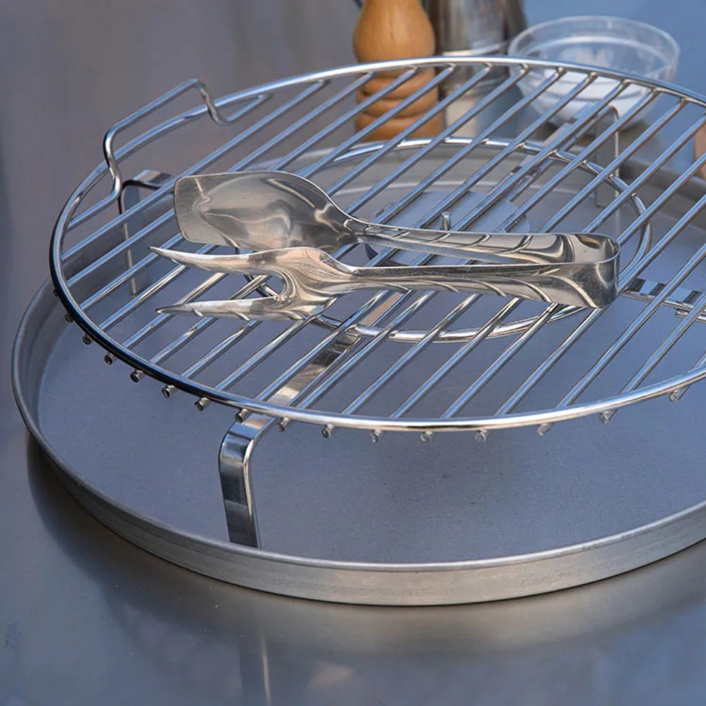 Alfa Forni BBQ 500 metal cooking grate with tongs on a stainless steel prep table
