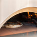 Cooking pizza in an Alfa Classico 2 Pizze Hybrid Oven with fire burning inside