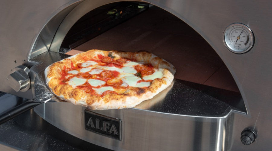 Pulling a pepperoni pizza out of the Alfa Forni Classico 2 Pizza Oven