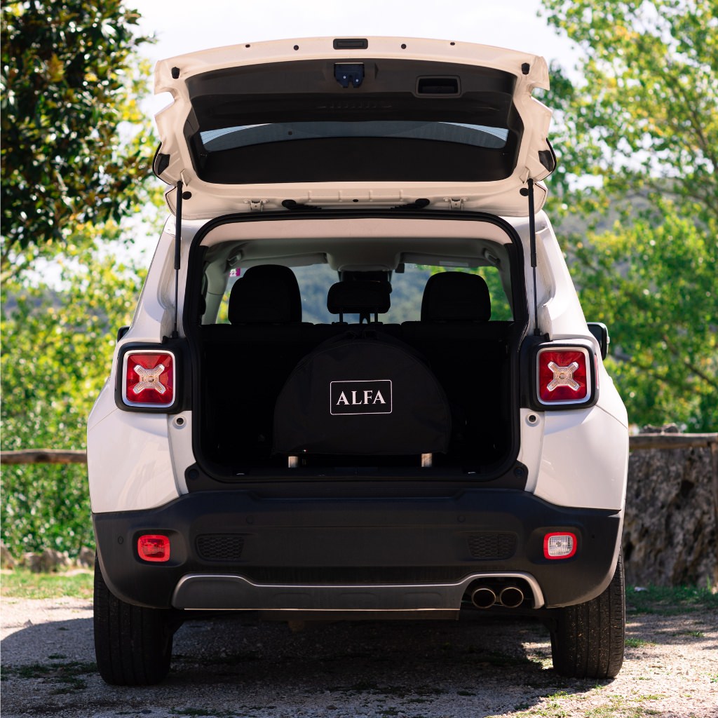 Alfa Moderno Portable Cover on the oven in the back of a white SUV with open trunk in a natural setting