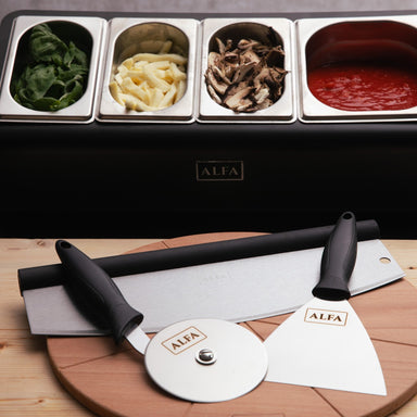 Alfa Pizza Topping Station with pizza preparation tools on a wooden board with ingredients for cooking pizzas.