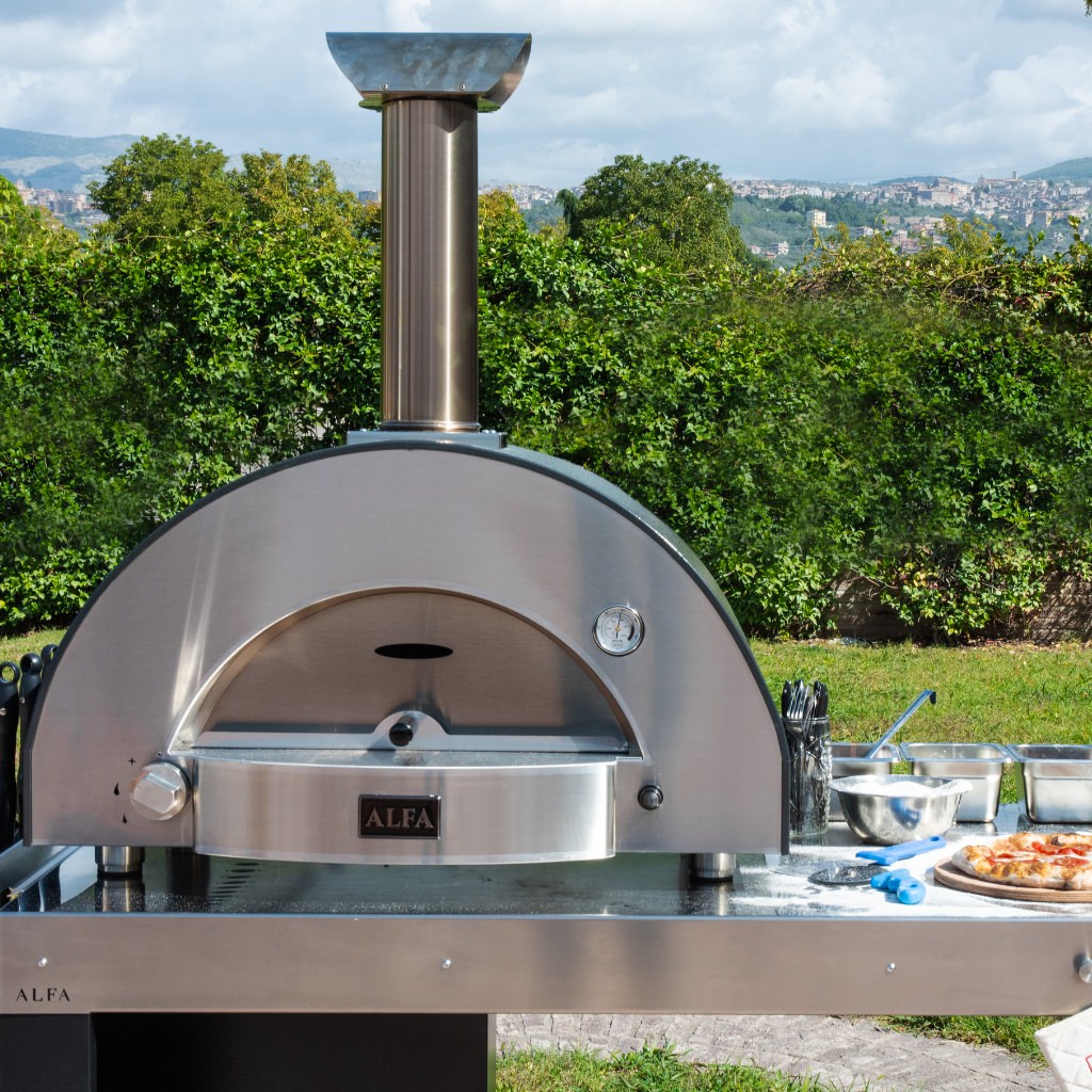 Forno Alfa Classico 2 Pizze Gas Pizza Oven on a stainless steel preparation table in an outdoor space