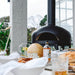 Polito Giotta Pizza Oven in outdoor kitchen with close up of table set up for pizza night