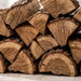 Close-up of stacked split oak cooking wood showing the cut ends and natural bark.