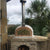 Authentic Pizza Ovens Pizzaioli Countertop Wood Fired Pizza Oven with Chimney Pipe Extension and Chimney Cap Sitting on a Custom Built Stone Base in Back Patio