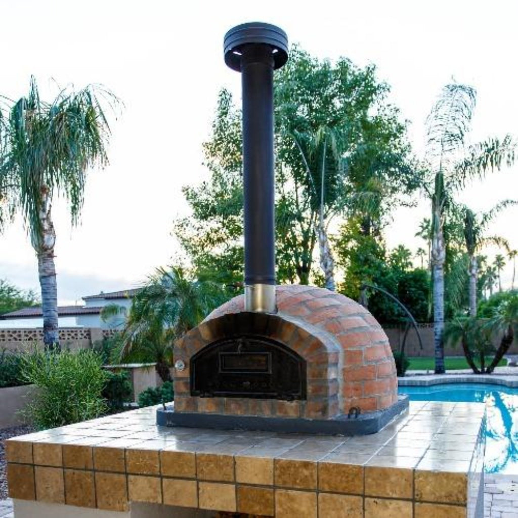 Authentic Pizza Ovens Premium Pizzaioli Rustic Finish Countertop Wood Fired Pizza Oven on Custom Built Tile Base in Backyard with Chimney Pipe Extension and Cap