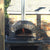 Authentic Pizza Ovens Premium Pizzaioli Stone Finish Countertop Wood Fired Pizza Oven on Back Patio with Fire Burning Inside Oven and Door Open