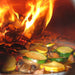 Chicago Brick Oven CBO 500 Countertop Wood Fired Pizza Oven Cooking Vegetables with Fire Burning in the Background of the Oven