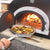 Chicago Brick Oven CBO 750 Countertop Wood Fired Pizza Oven Cooking Vegetables with Fire Burning Inside Oven
