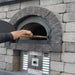 Chicago Brick Oven CBO 750 Hybrid Gas and Wood Fired Pizza Oven DIY Kit Custom Stone Back Patio Home Installation with Door Open and Cooking Pizza