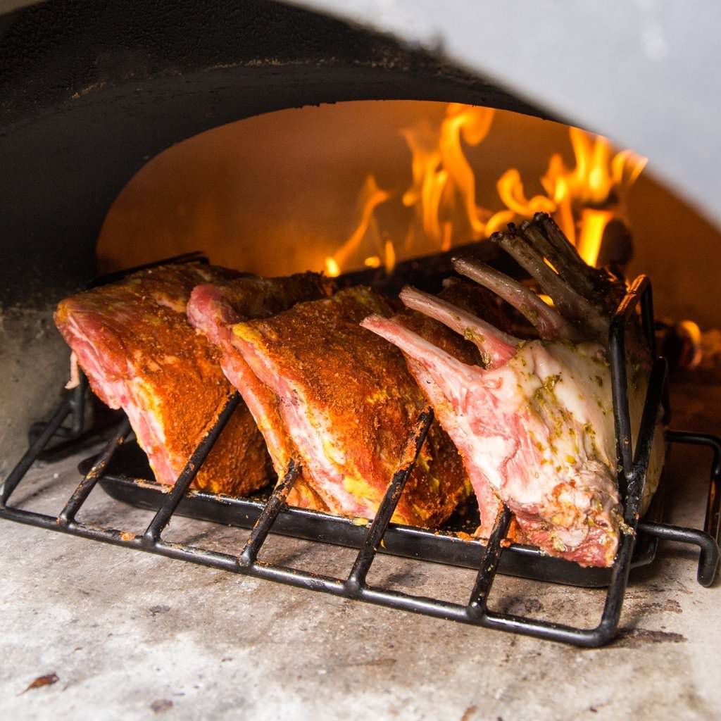 Chicago Brick Oven CBO 750 Wood Fired Pizza Oven DIY Kit Cooking Ribs with Oven Door Open and Wood Burning in the Oven